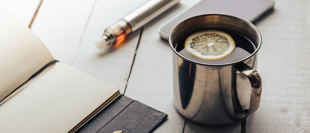 pohár s čajom a elektronickou cigaretou