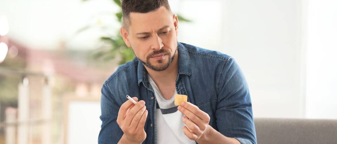 muž si vyberá medzi cigaretou a náplasťou