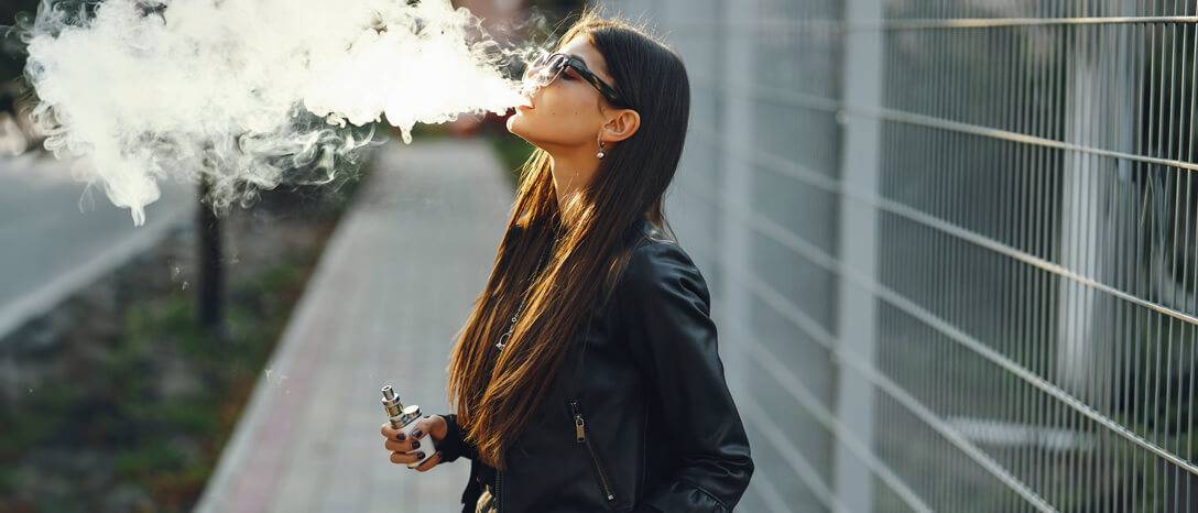 žena vyfukuje dym z elektronickej cigarety